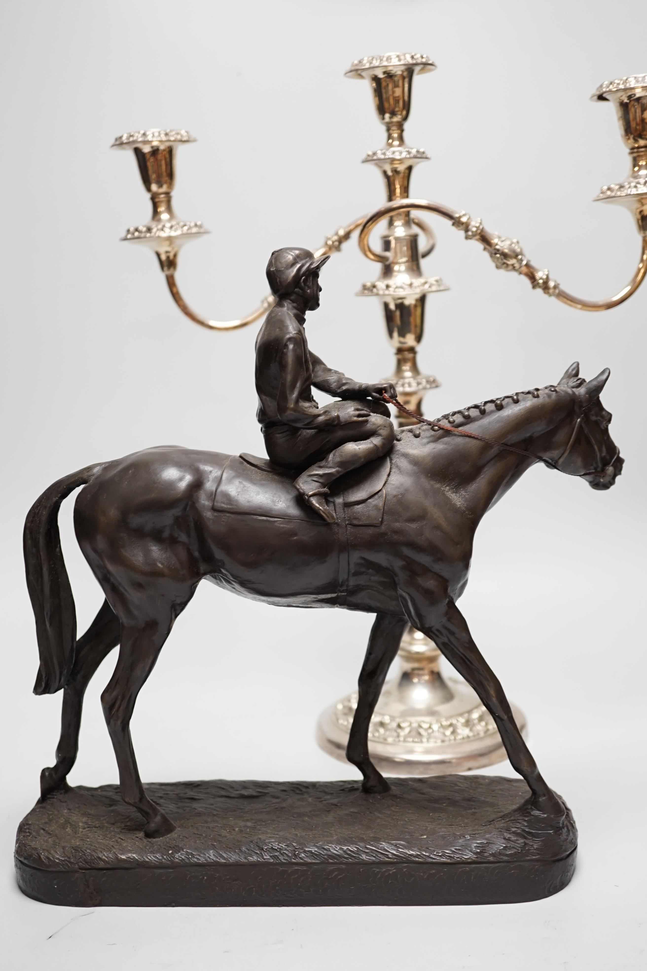 A bronzed resin racehorse and jockey group and a silver-plated three branch candelabrum -45cm high